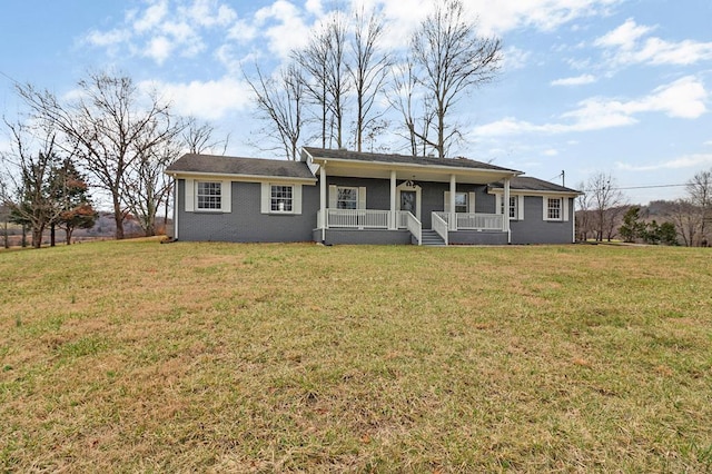 ranch-style house featuring covered porch and a front lawn