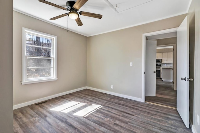 unfurnished bedroom with attic access, visible vents, baseboards, dark wood-style floors, and ceiling fan