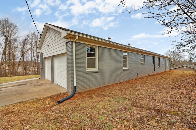 view of home's exterior with a detached garage and brick siding