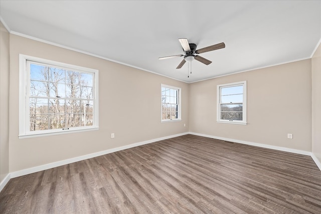 empty room with a ceiling fan, baseboards, ornamental molding, and wood finished floors