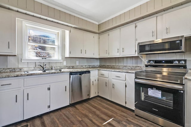 kitchen featuring dark wood finished floors, crown molding, stainless steel appliances, white cabinetry, and a sink