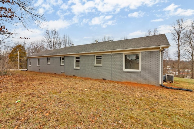 back of property featuring brick siding, a yard, and central AC unit