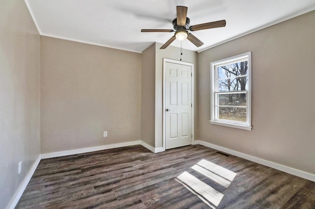 unfurnished bedroom featuring ceiling fan, dark wood-type flooring, visible vents, and baseboards