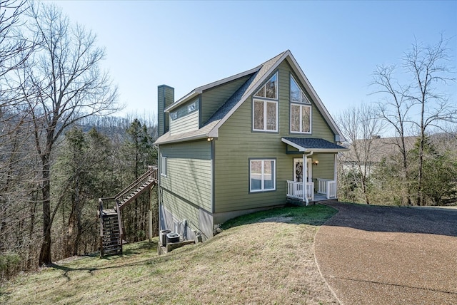 view of front of house with a chimney, stairway, roof with shingles, a front lawn, and central AC