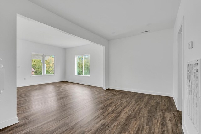 spare room with dark wood finished floors and baseboards