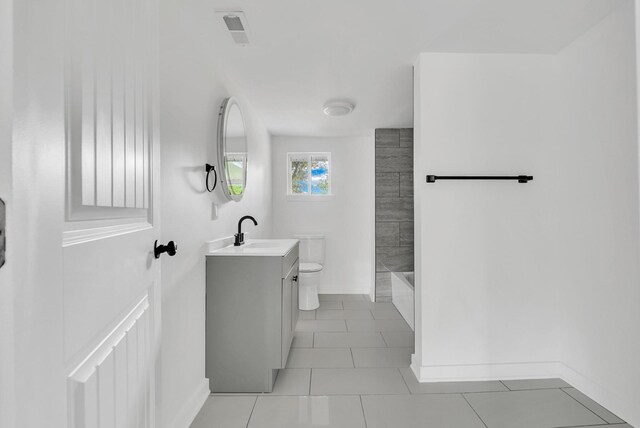 full bathroom featuring baseboards, toilet, tile patterned flooring, vanity, and washtub / shower combination