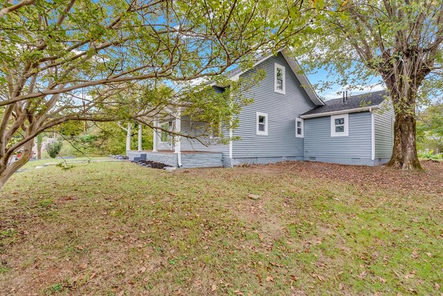 view of home's exterior featuring a shingled roof, crawl space, and a lawn