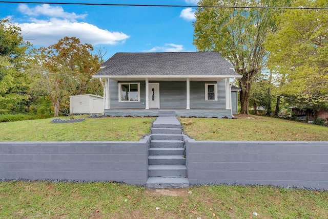 bungalow-style house featuring covered porch, a front lawn, and roof with shingles