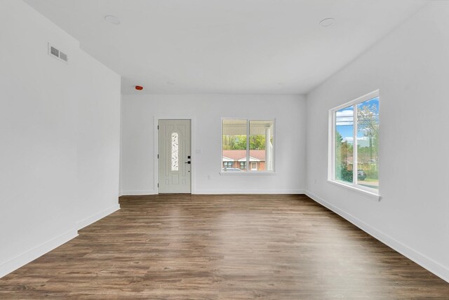 entrance foyer with dark wood-style floors, baseboards, and visible vents