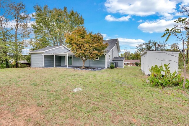 rear view of house featuring a lawn