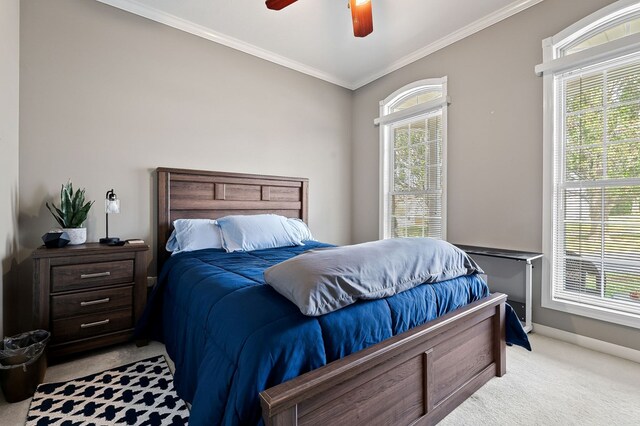 bedroom featuring ornamental molding, multiple windows, and light colored carpet