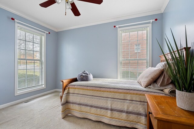 bedroom featuring visible vents, ornamental molding, a ceiling fan, light carpet, and baseboards