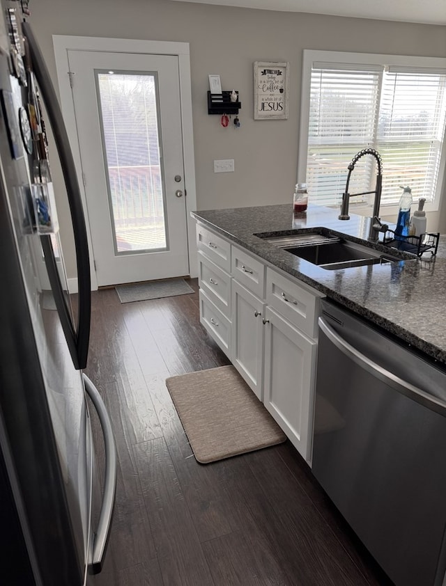 8501 Faix Rd, Byrdstown, TN 38549 - kitchen with freestanding refrigerator, stainless steel dishwasher, a sink, dark wood finished floors, and white cabinetry