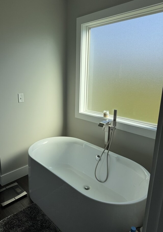 8501 Faix Rd, Byrdstown, TN 38549 - bathroom featuring wood finished floors, a soaking tub, healthy amount of natural light, and baseboards