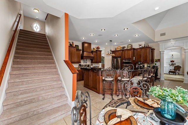 dining area with visible vents, stairway, light tile patterned flooring, and decorative columns