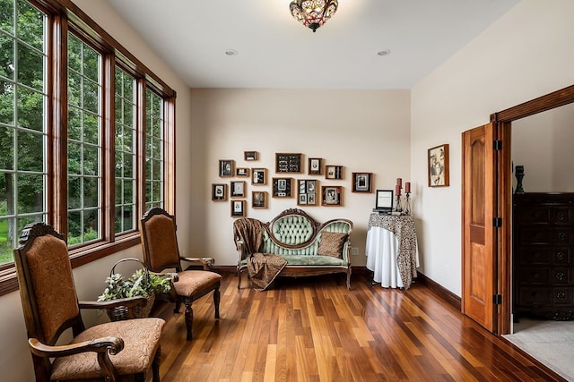 sitting room with baseboards and dark wood-type flooring