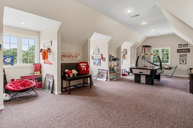 recreation room featuring lofted ceiling, carpet floors, plenty of natural light, and visible vents