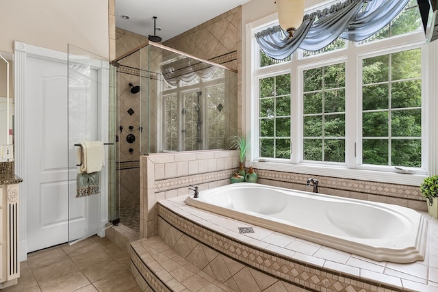 bathroom with a shower stall, a bath, and tile patterned floors