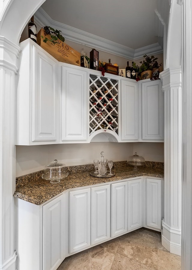 bar with a dry bar, ornate columns, and crown molding