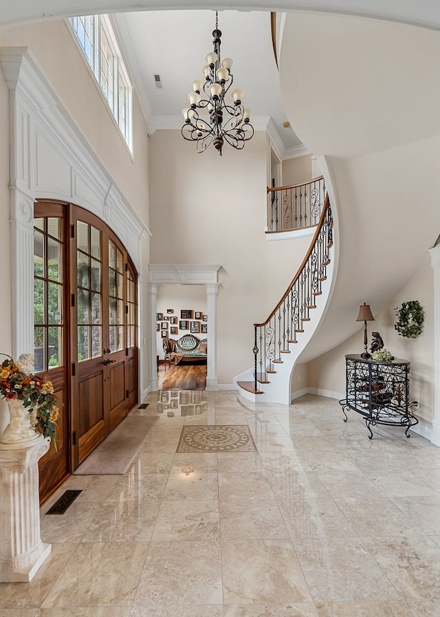 foyer featuring marble finish floor, stairway, visible vents, and an inviting chandelier