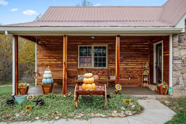 exterior space featuring stone siding, covered porch, and metal roof