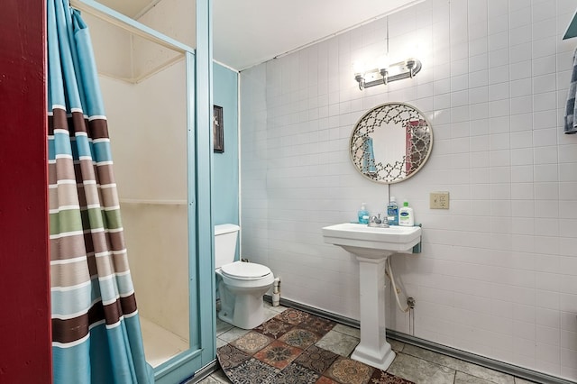 full bath with tile walls, tile patterned flooring, a shower stall, and toilet