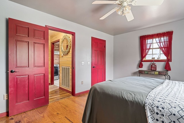 bedroom with ceiling fan, light wood-style flooring, visible vents, baseboards, and washer / dryer