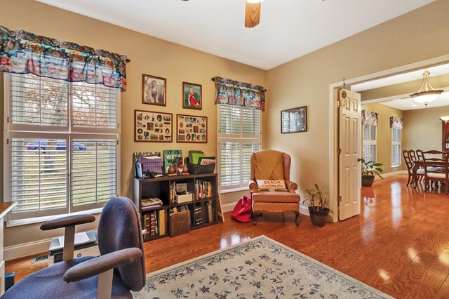 office space featuring ceiling fan, visible vents, baseboards, and wood finished floors