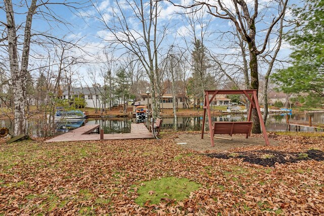 view of yard featuring a water view and a dock