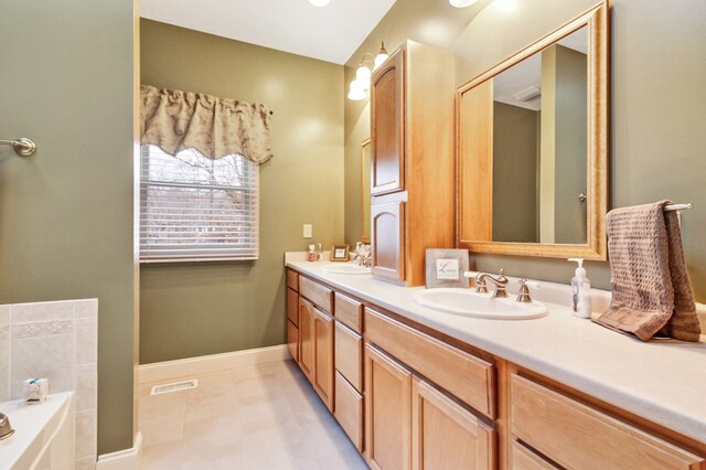 full bath with double vanity, baseboards, visible vents, a sink, and a bath