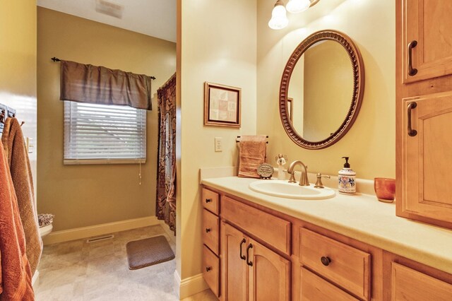 full bathroom with vanity and baseboards