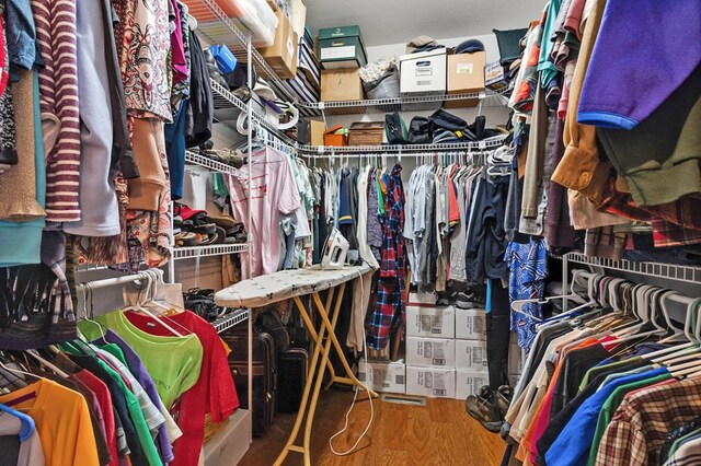 walk in closet with wood finished floors