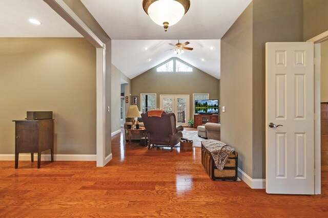 interior space with high vaulted ceiling, wood finished floors, and baseboards