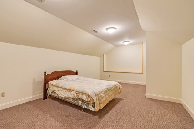 bedroom with lofted ceiling, carpet flooring, visible vents, and baseboards