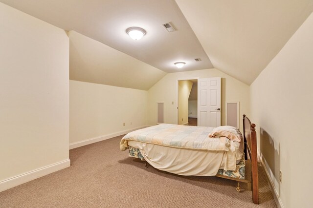 bedroom with carpet floors, visible vents, vaulted ceiling, and baseboards