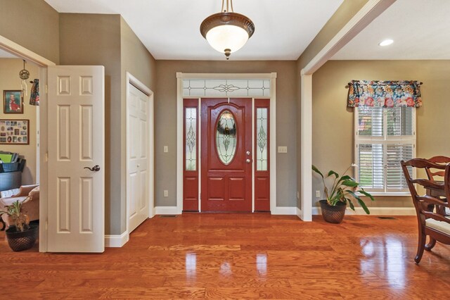 foyer entrance with visible vents, baseboards, and wood finished floors