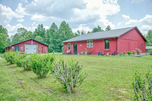 5088 Baptist Ridge Rd, Hilham, TN 38568 - view of side of property with a detached garage, an outdoor structure, a yard, and a metal roof