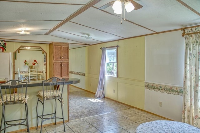 5088 Baptist Ridge Rd, Hilham, TN 38568 - kitchen featuring a textured ceiling, freestanding refrigerator, lofted ceiling, a kitchen breakfast bar, and ceiling fan