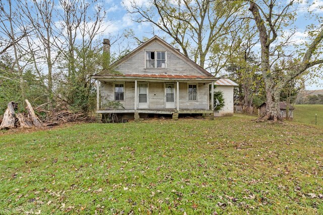 view of front facade with a chimney and a front yard