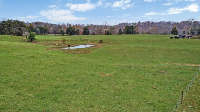 surrounding community with a rural view and a yard