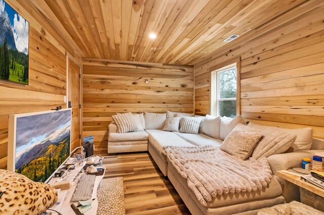 living area featuring wood walls, wood ceiling, and wood finished floors