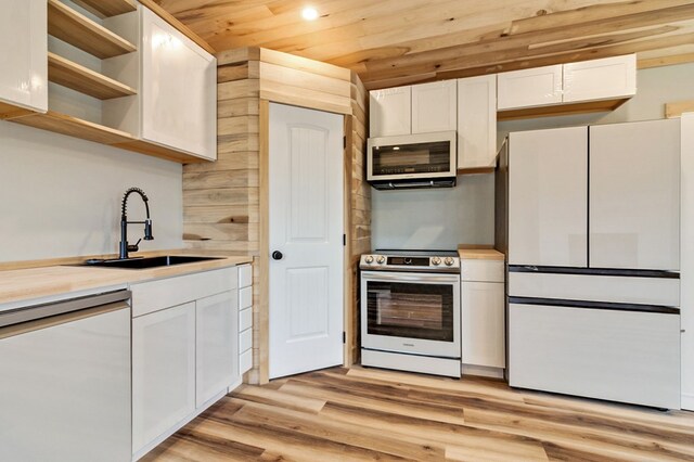 kitchen featuring white appliances, light countertops, white cabinetry, open shelves, and a sink