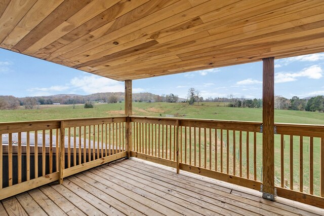 deck featuring a rural view and a lawn