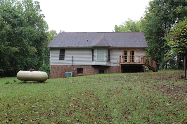 rear view of house featuring a lawn, a wooden deck, and stairs