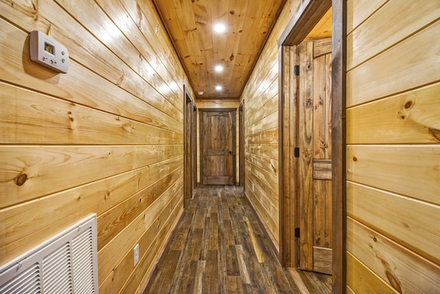 hallway featuring wood ceiling, dark wood finished floors, and wooden walls