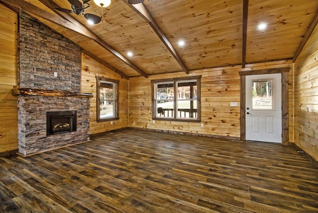 unfurnished living room featuring wooden walls, wood ceiling, dark wood-type flooring, vaulted ceiling with beams, and a stone fireplace