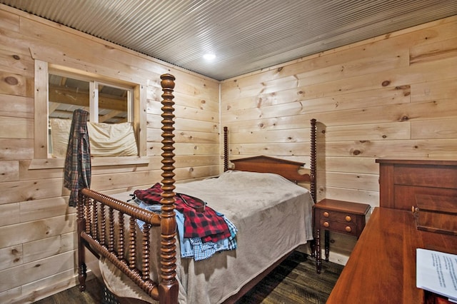 bedroom with dark wood-type flooring and wood walls