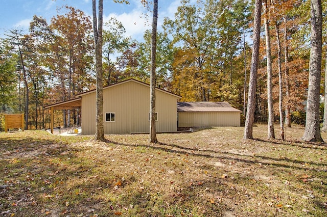 view of side of property featuring an outbuilding, an outdoor structure, and a lawn