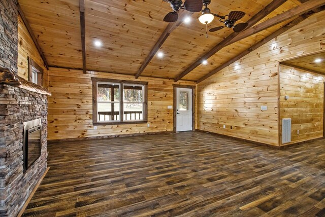 unfurnished living room featuring dark wood-style flooring, vaulted ceiling with beams, wooden walls, a stone fireplace, and wooden ceiling