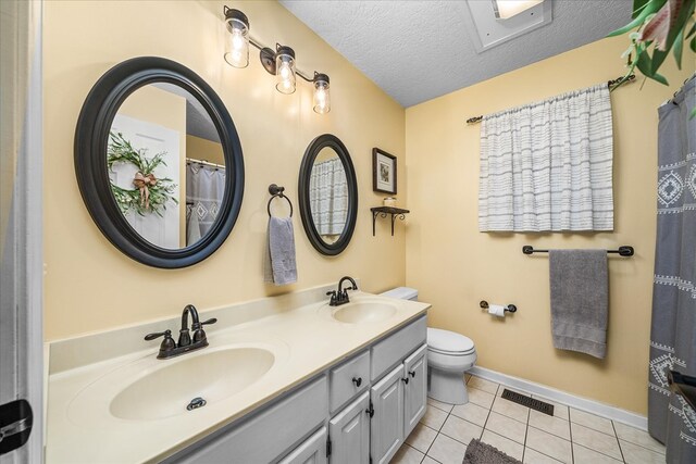 bathroom featuring a textured ceiling, visible vents, a sink, and tile patterned floors